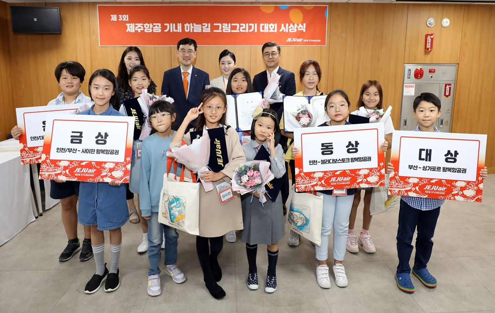 지난 19일 서울 강서구 하늘길 제주항공 라운지에서 진행된 ‘제3회 제주항공 기내 하늘길 그림 그리기 대회’에서 수상자와 이석주 대표이사, 객실승무원들이 기념사진을 찍고 있다. [제주항공 제공]
