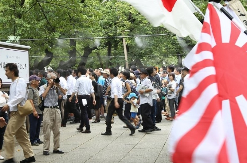 일본의 패전일이자 한국의 광복절인 지난 8월 15일 A급 전법들이 합사된 일본 도쿄(東京)의 야스쿠니신사(靖國神社)에서 전범기인 욱일기(旭日旗)가 휘날리는 가운데 참배객들이 걸어가고 있다. [연합]