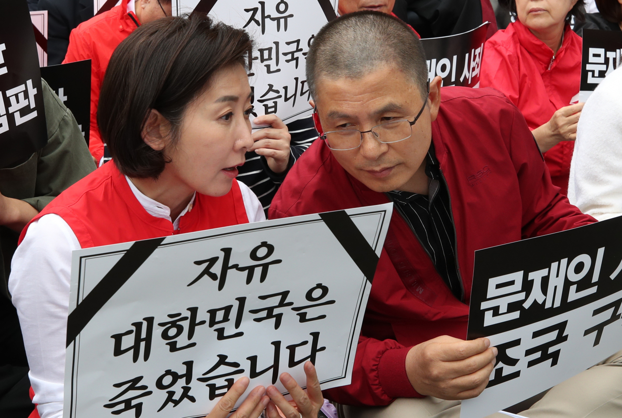 자유한국당 황교안 대표와 나경원 원내대표가 21일 오후 서울 광화문 세종문화회관에서 열린 '문재인 정권 헌정 유린 중단과 위선자 조국 파면 촉구' 대규모 장외집회에 참석해 대화를 하고 있다. [연합]