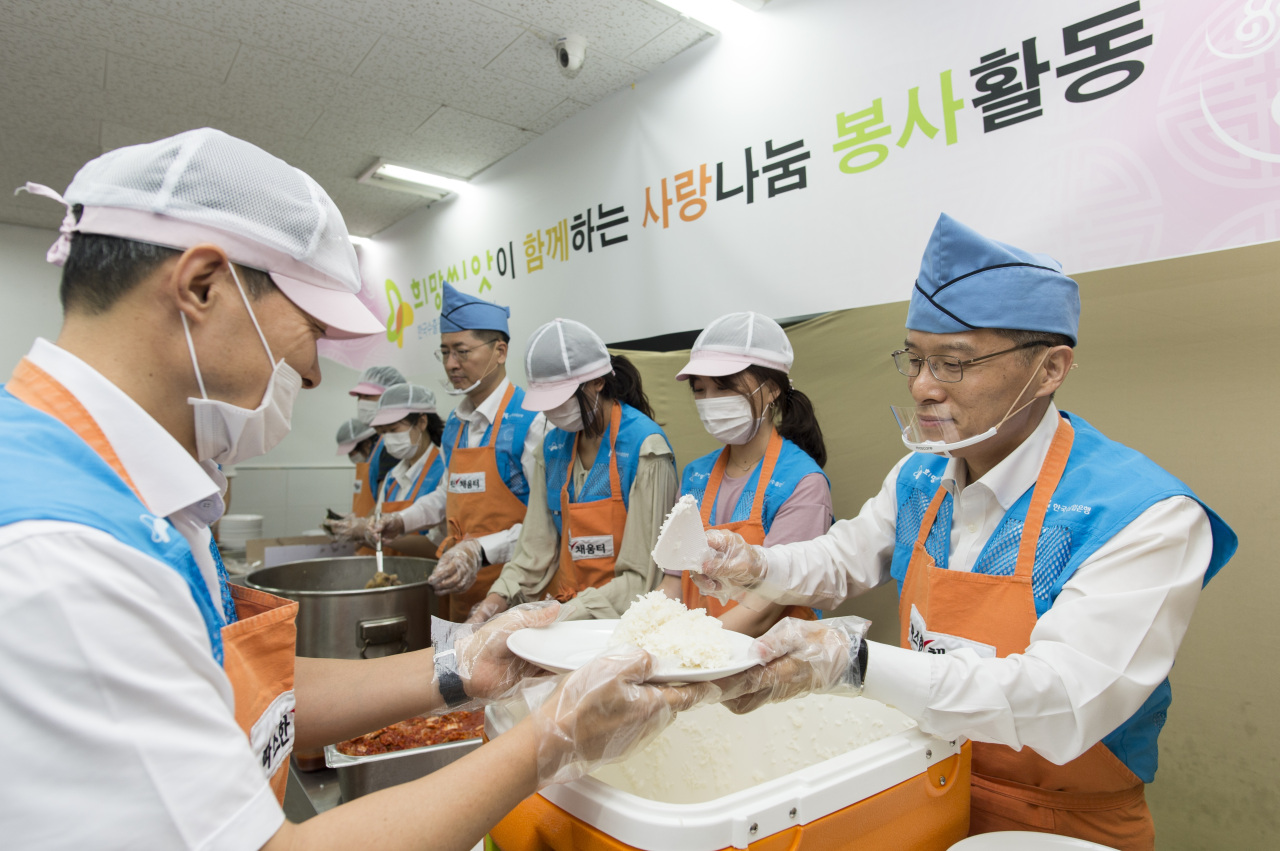 Eximbank Deputy President Kang Seung-joong (right) helps serve meals for the homeless at a soup kitchen near Seoul Station on Sept. 10. (Eximbank)