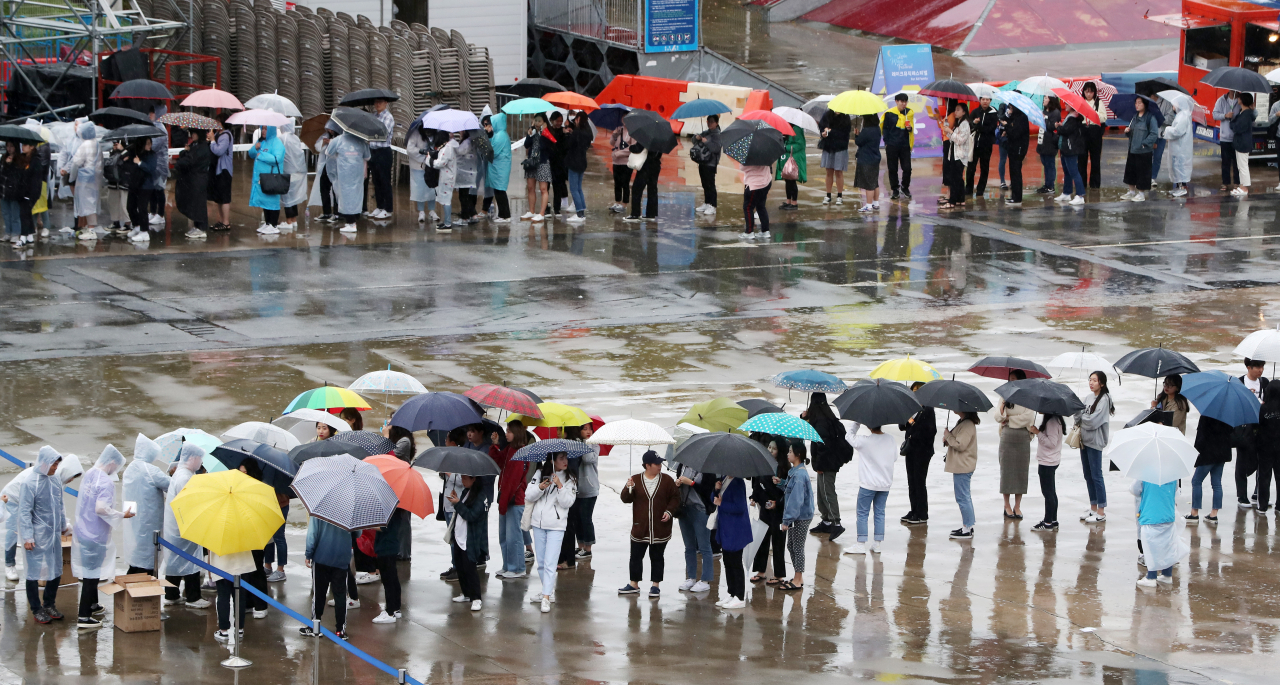제17호 태풍 '타파'가 북상 중인 22일 강원 춘천시 공지천 유원지 야외공연장에서 우산을 쓴 관람객들이 콘서트 입장을 기다리며 줄지어 서 있다. 연합뉴스