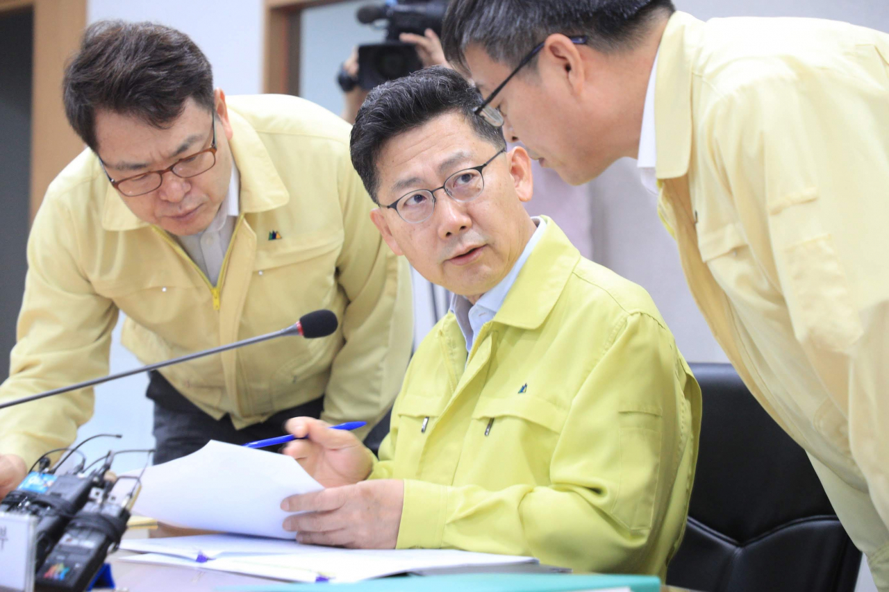 김현수(가운데) 농림축산식품부 장관이 23일 아침 아프리카돼지열병(ASF) 방역추진상황 점검회의에 앞서 박병홍(오른쪽) 식품산업정책실장(오른쪽), 김정욱 대변인과 이날 새벽 경기 김포에서 들어 온 ASF 의심신고 상황과 대처 등 회의 자료를 점검하고 있다. [농림축산식품부 제공]