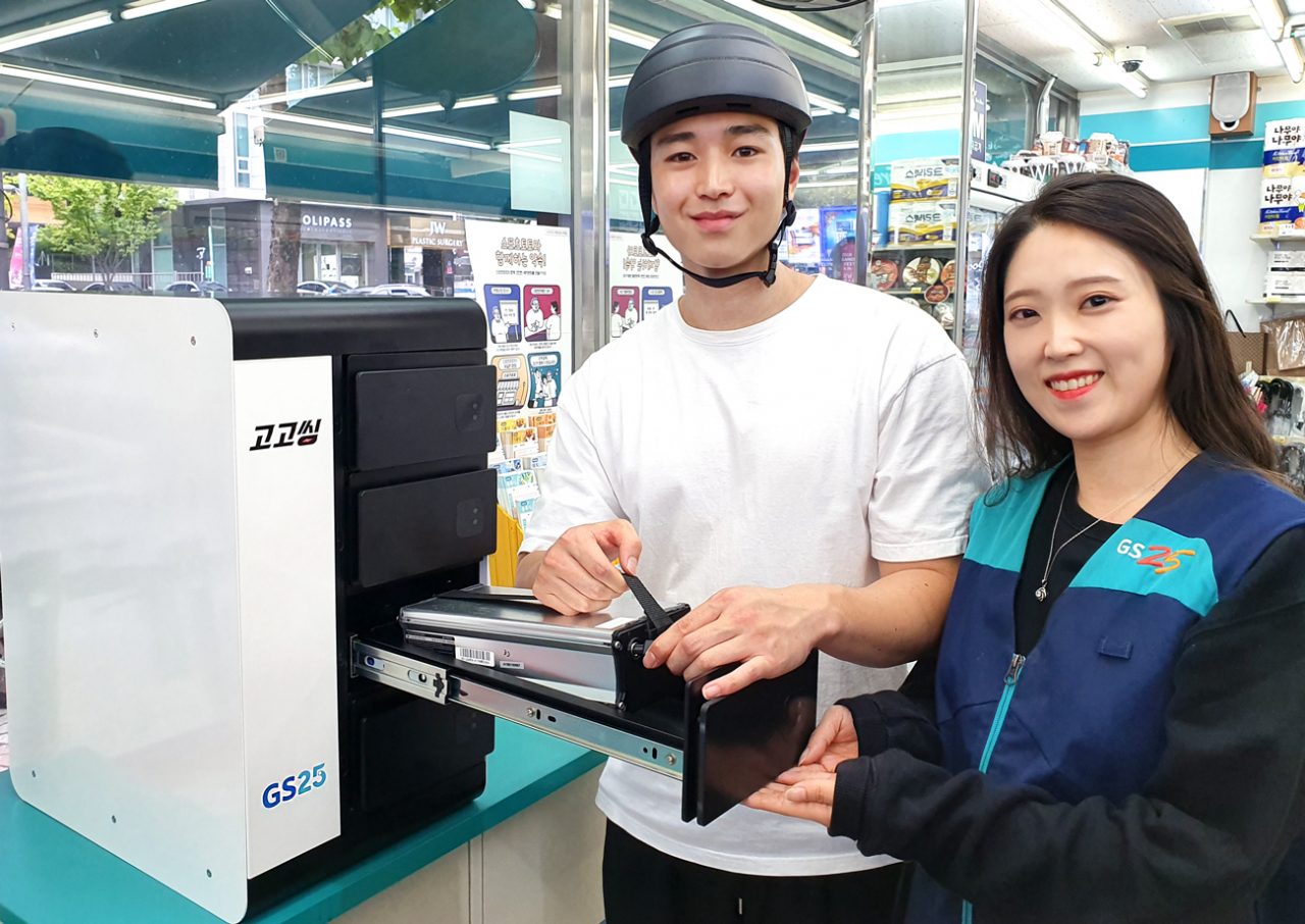 GS25 직원이 고고씽 직원과 함께 전동 킥보드 배터리 충전을 시연하고 있다. [사진제공=GS25]