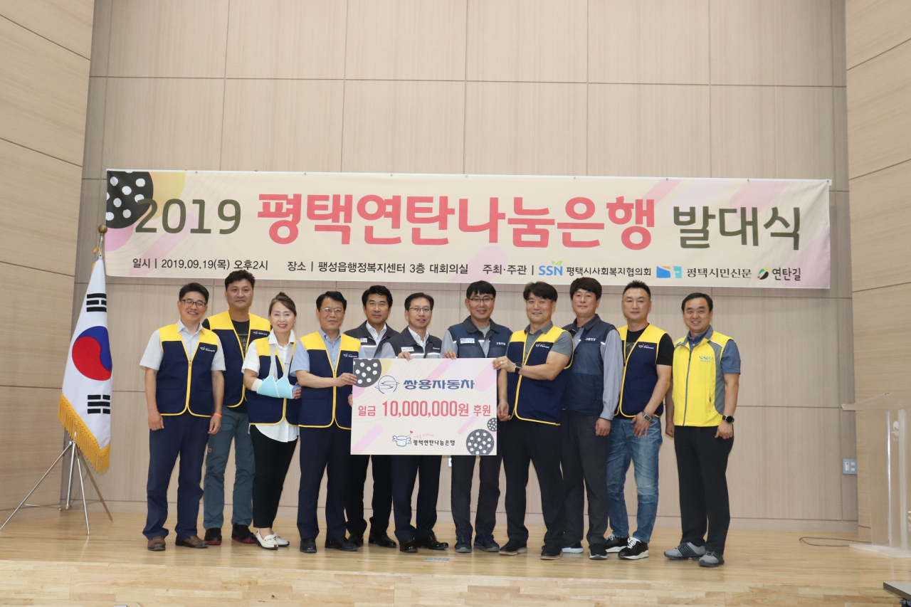 쌍용자동차가 2019 평택연탄나눔은행에 후원금을 전달하고 연탄 나눔 봉사활동에 참여했다. 평택연탄나눔은행 발대식 후 관계자들이 기념촬영을 하고 있다.[쌍용차 제공]