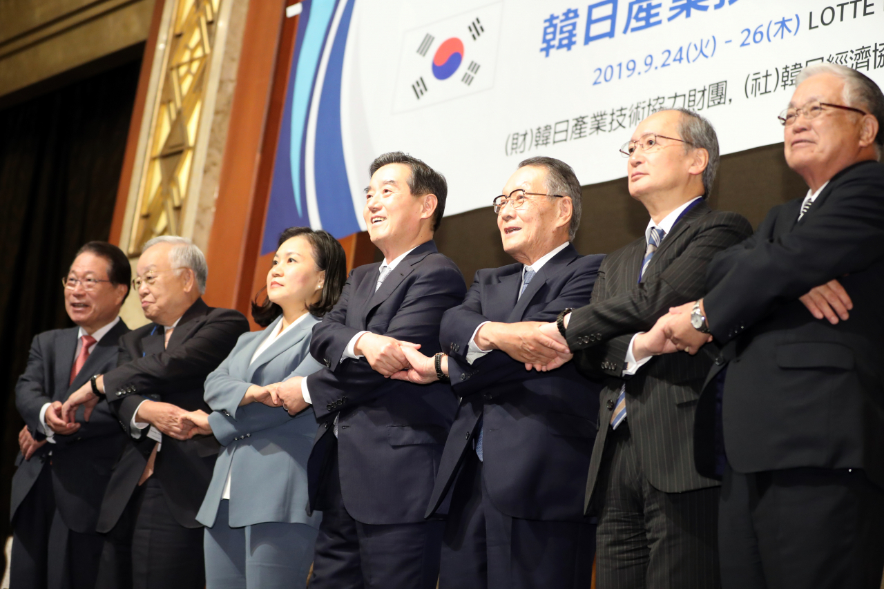 24일 오후 서울 중구 소공동 롯데호텔에서 열린 제51회 한일경제인회의에서 주요 참석자들이 손을 맞잡고 기념촬영을 하고 있다. 왼쪽부터 유명환 전 외교통상부 장관, 손경식 한국경영장총협회 회장, 유명희 통상교섭본부장, 김윤 한일경제협회 회장(삼양홀딩스 회장), 사사키 미키오(佐佐木幹夫) 일한경제협회 회장(미쓰비시상사 특별고문), 나가미네 야스마사 주한 일본대사, 고가 노부유키 노무라 증권 회장. [연합]