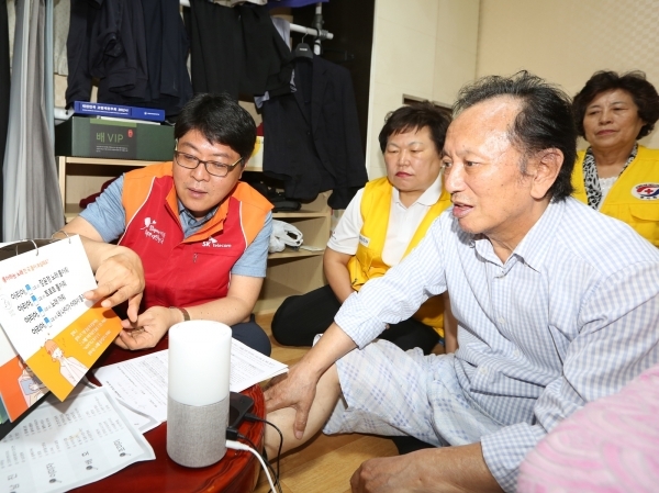 SKT official explain how to use the smart speaker Nugu to a senior citizen living alone. SKT