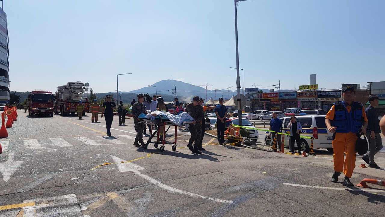 Soldiers move a bed-ridden patient to an ambulance.(Choi Ji-won/The Korea Herald)