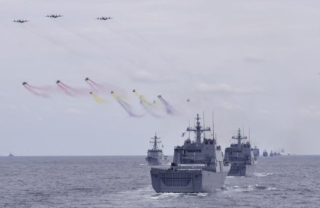 Escorted by patrol aircraft and anti-submarine helicopters, South Korean combat vessels rehearse maneuvers ahead of Jeju International Fleet Review in October last year. (Republic of Korea Navy)