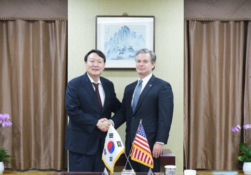 South Korea's Prosecutor General Yoon Seok-youl (L) shakes hands with U.S. Federal Bureau of Investigation (FBI) Director Christopher Wray ahead of talks in Seoul on Sept. 24, 2019, in this photo provided by the Supreme Prosecutors' Office. (Yonhap)