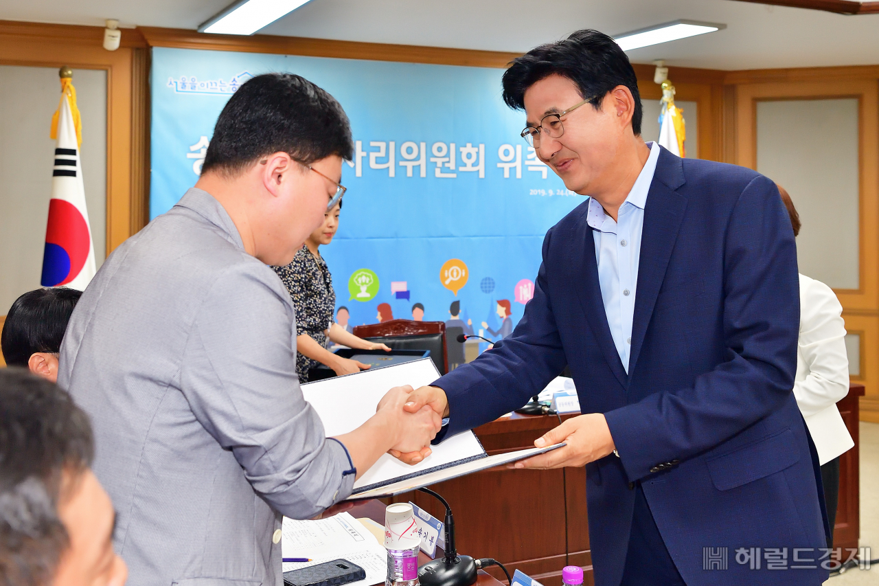 박성수(오른쪽) 서울 송파구청장이 한 일자리 위원에게 위촉장을 전달하고 있다. [송파구]