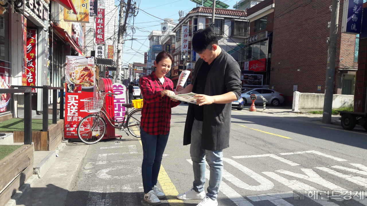 자양동 앙꼬치 거리에서 중국어 안내를 하고 있는 장유진 주무관(왼쪽). [광진구 제공]