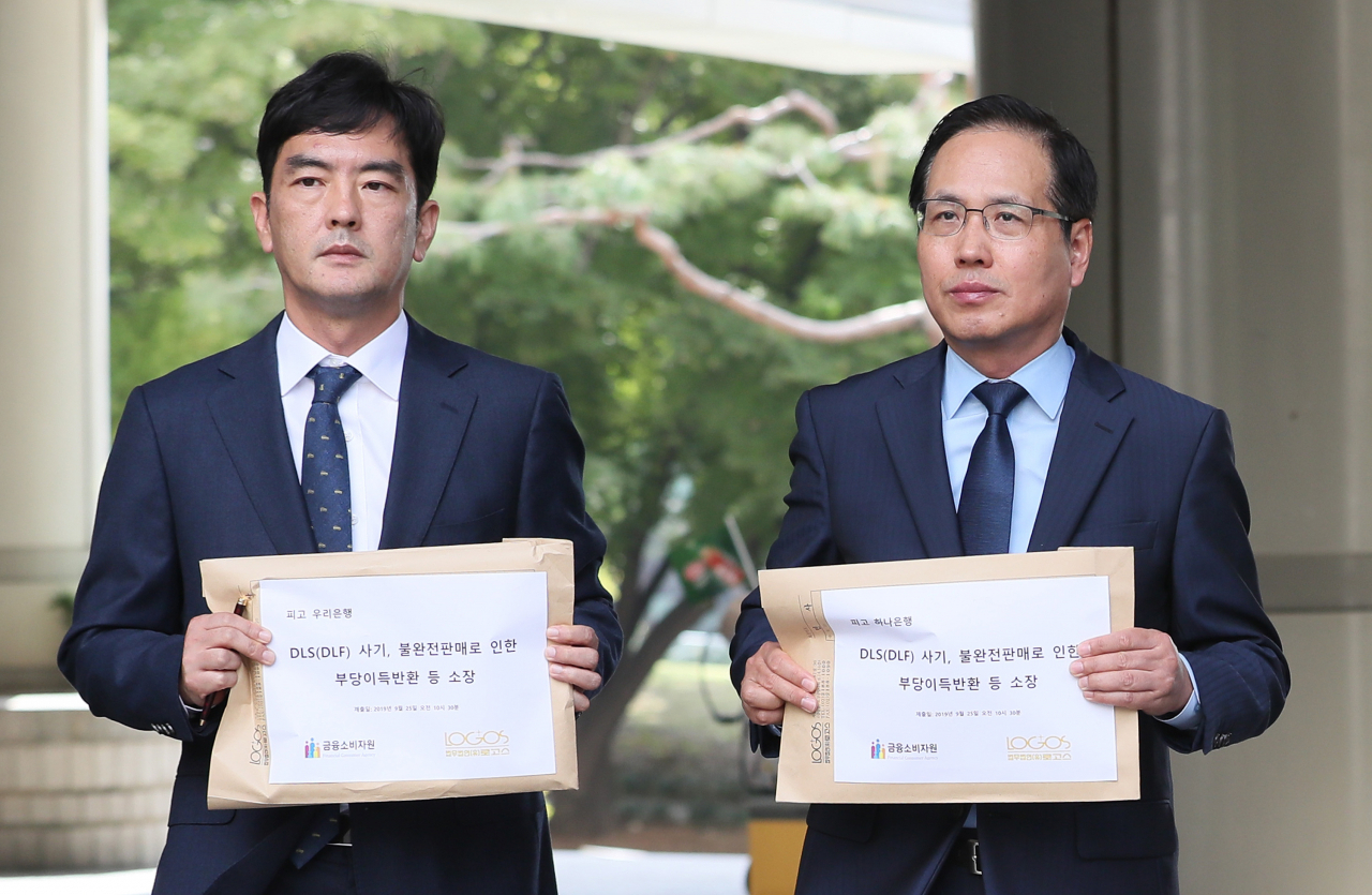 조남희 금융소비자원장(오른쪽)과 법무법인 로고스 전문수 변호사가 25일 오전 서울 서초구 서울중앙지법에서 우리은행과 하나은행과 판매한 해외금리 연계 파생결합상품(DLS,DLF) 피해 관련 계약 취소 및 손해배상 청구 소송을 제기했다. [연합]