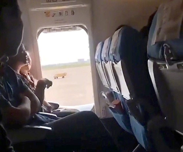 지난 23일 중국 우한 톈허 국제공항을 출발해 란저우로 향하려던 샤먼항공 여객기에서 한 50대 중국인 여성이 이륙 준비 중이던 비행기 비상문을 연 뒤 앉아 있다. [웨이보 캡처]