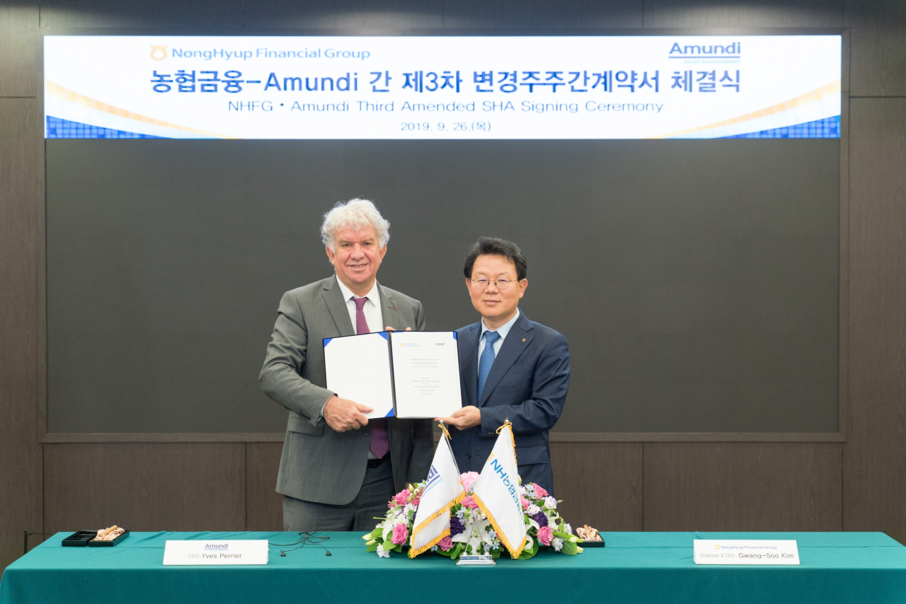 김광수 농협금융 회장(오른쪽)과 이브 페리에 아문디 회장이 26일 계약서에 서명 후 기념촬영을 하고 있다.