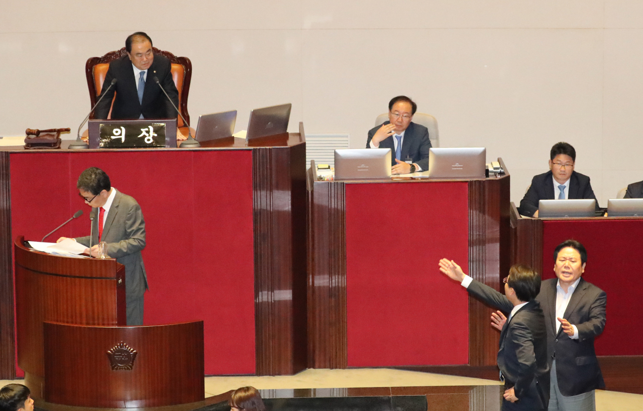 곽상도 자유한국당 의원이 26일 오후 국회 본회의장에서 열린 정치 분야 대정부질문에서 조국 법무부 장관의 호칭을 '피의자 조국' 이라고 부르자 더불어민주당 이원욱 의원이 국회의장에게 손들어 항의하고 있다. [연합]