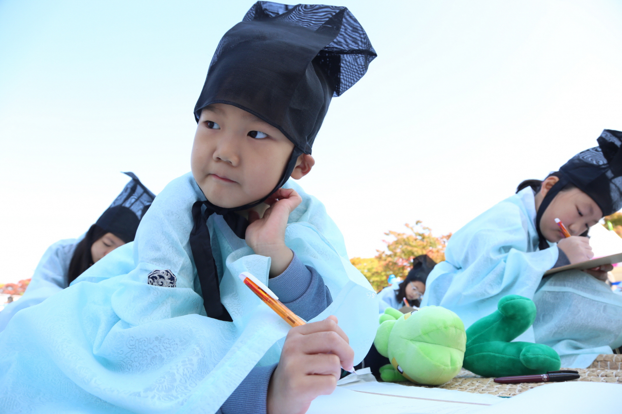 지난해 구로구 주최 ‘과거시(詩) 경연대회’에 출전한 한 어린이가 도포와 유건을 쓴 채 시상을 떠올리는 지 골똘한 표정을 하고 있다. [구로구 제공]