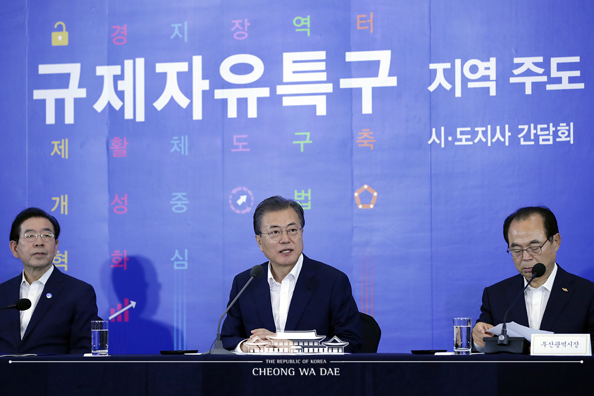 〈사진〉문재인(가운데) 대통령이 7월 부산 누리마루 APEC 하우스에서 부산 블록체인특구 관련 선진 기술 확보와 지역 경제 활성화를 강조했다. 오른쪽은 오거돈 부산광역시장[청와대공동사진단]