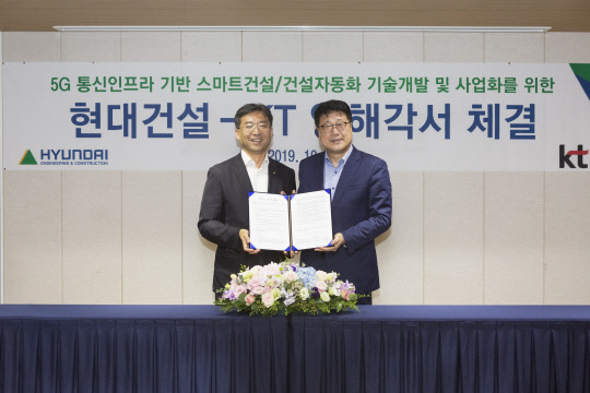 현대건설 R&D센터장인 이석홍 전무(오른쪽)와 KT 네트워크전략본부장인 서창석 전무가 스마트 건설·건설자동화 기술개발 및 사업화를 위한 업무 협약을 맺은 후 기념 촬영을 하고 있다. [사진=현대건설]