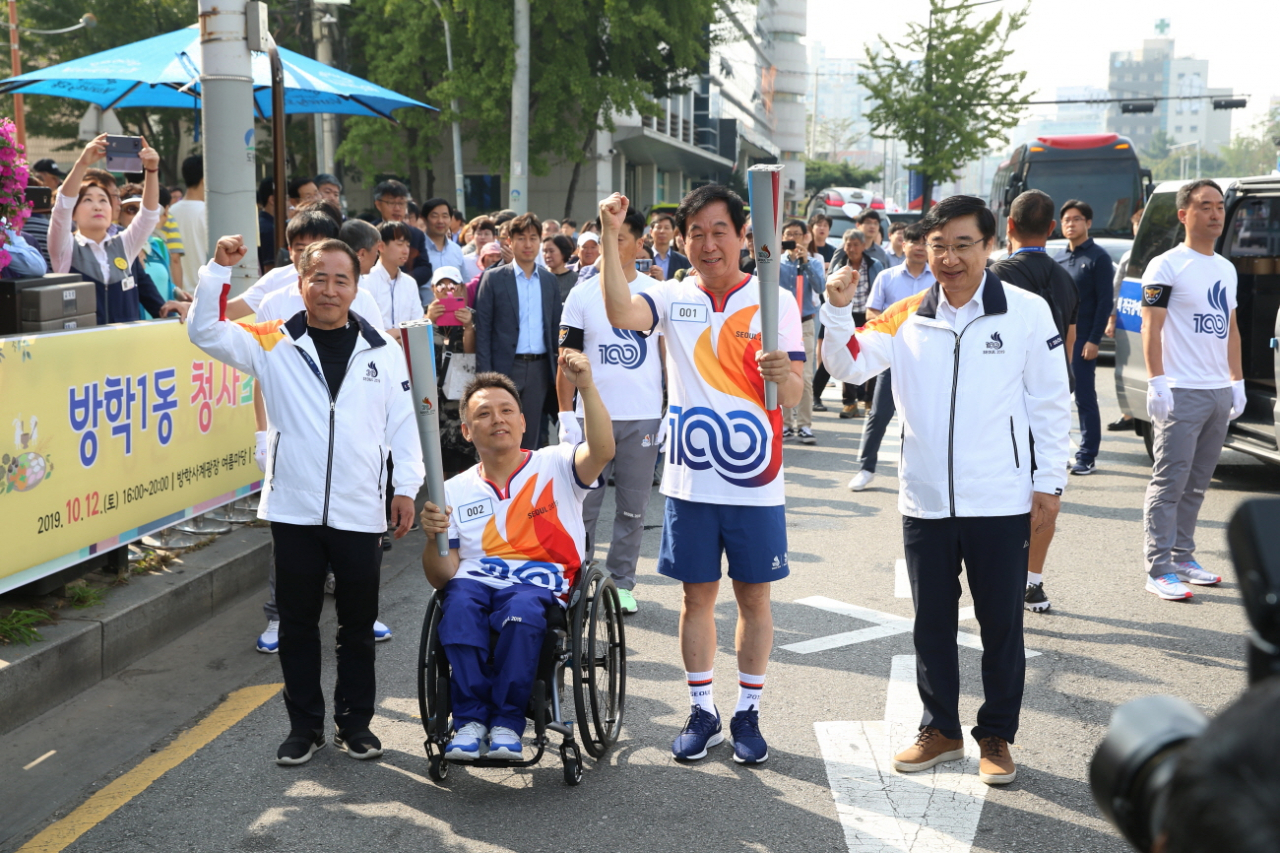 이동진(맨오른쪽) 도봉구청장이 성화불꽃을 전달받고 있은 성화봉송 주자들과 함께 기념사진을 찍고 있다. [도봉구 제공]