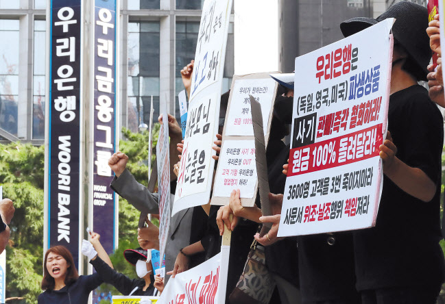 1일 오전 서울 중구 우리은행 본점 앞에서 열린 ‘DLS·DLF 판매 국정조사 및 피해 대책 마련 촉구 기자회견’에서 피해자들이 구호를 외치고 있다. [연합]