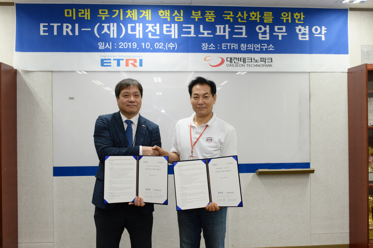 강성원(왼쪽) ETRI ICT창의연구소장과 최수만 대전테크노파크 원장이 군수용 반도체 관련 공동연구 수행을 위한 업무협약을 체결하고 있다. [ETRI 제공]