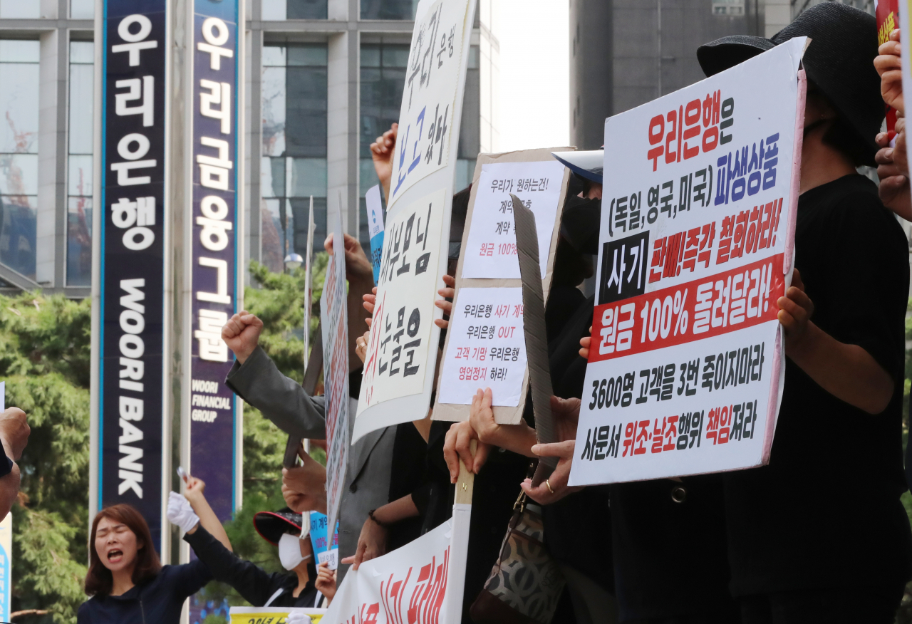 지난 1일 오전 서울 중구 우리은행 본점 앞에서 열린 'DLS·DLF 판매 국정조사 및 피해 대책 마련 촉구 기자회견'에서 피해자들이 구호를 외치고 있다. [연합]