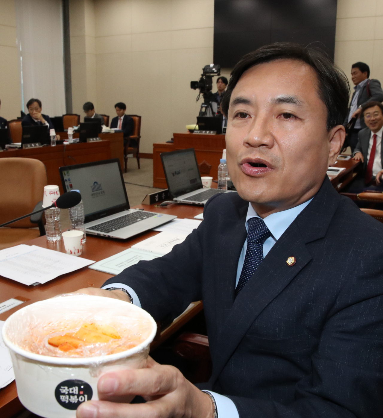 7일 국회에서 열린 정무위원회 국정감사에서 자유한국당 김진태 의원이 조성욱 공정위원장에게 국대떡볶이를 들어 보이며 프랜차이즈 업체 관련 질의하고 있다. [연합]