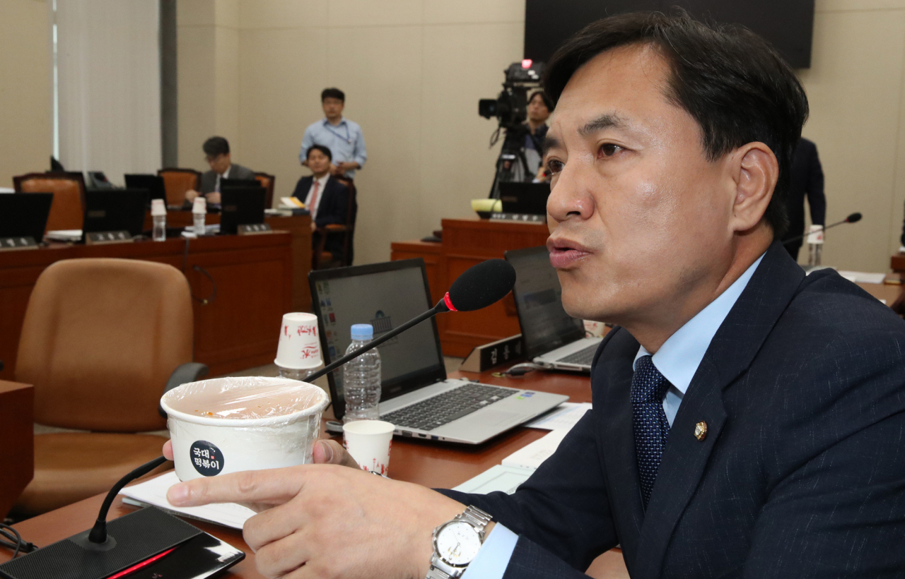 7일 국회에서 열린 정무위원회 국정감사에서 김진태 자유한국당 의원이 조성욱 공정위원장에게 국대떡볶이를 들어 보이며 프랜차이즈 업체 관련 질의하고 있다. [연합]