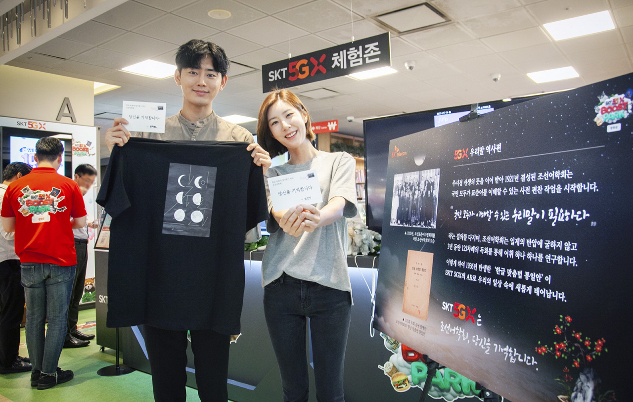 SK텔레콤 홍보 모델들이 서울 광화문 교보문고 내 ‘5GX 체험존’에 마련된 ‘우리말 역사존’을 소개하고 있다. [SK텔레콤 제공]