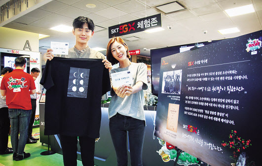 SK텔레콤 홍보 모델들이 서울 광화문 교보문고 내 ‘5GX 체험존’에 마련된 ‘우리말 역사존’을 소개하고 있다. [SK텔레콤 제공]