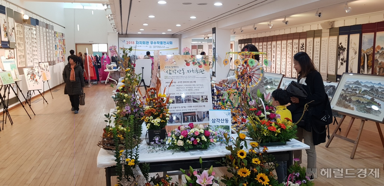 강북구민들이 지난해 10월 30일부터 열린 강북구 자치회관 우수작품 전시회에서 작품을 감상하고 있다 . [강북구]