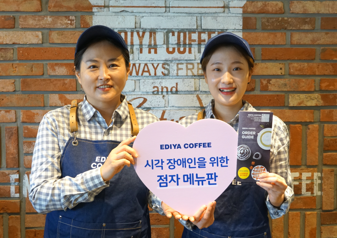 이디야커피가 시각장애인을 위해 제작한 점자메뉴판을 매장 점주와 아르바이트생이 선보이고 있다. [이디야커피 제공]