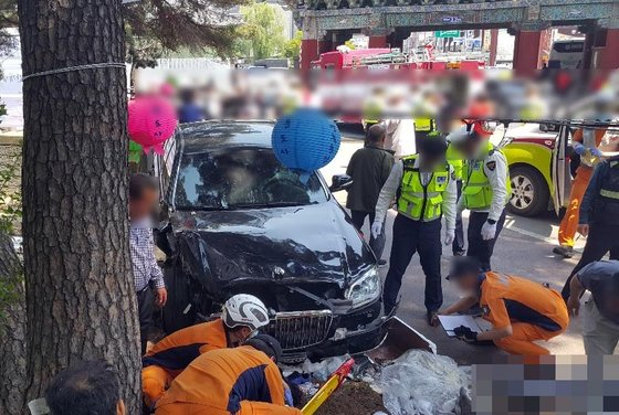 고령운전자의 운전면허 자진반납을 이끌어내는 방법이 진화하고 있다. 자동차 보험 가입 증서를 제출하는 고령운전자에게 총 30만원의 교통카드를 지급하는 가 하면, 5년간 버스 이용료를 면제해주기도 한다. 사진은 지난 5월 12일 경남 양산 통도사 입구에서도 있었던 교통사고 현장. A(75)씨가 몰던 차량이 인파를 덮쳐 1명이 숨지고 12명이 다쳤다. [연합뉴스]