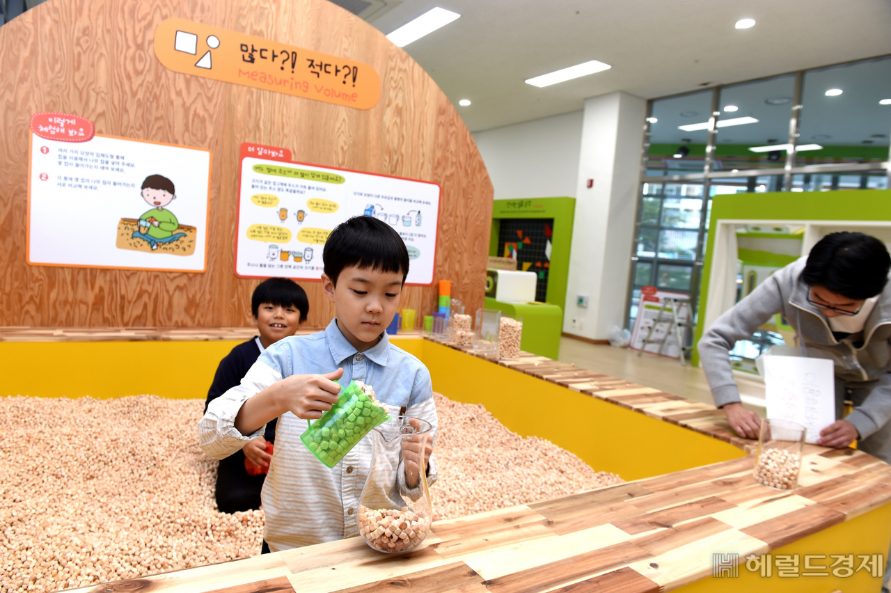 수학문화관 1층에서 한 어린이가 편백나무 칩으로 부피의 개념을 익히고 있다. [노원구 제공]