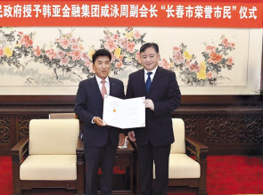 지난 9일 중국 창춘시정부에서 열린 명예시민증 수여식에서 함영주 하나금융그룹 부회장(왼쪽)이 리우신 창춘시 시장으로부터 기념패를 수여받고 있다. [하나금융 제공]