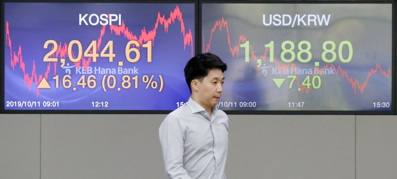 코스피가 외국인 및 기관 투자자 매수에 힘입어 2,040선을 회복한 11일 오후 서울 중구 KEB하나은행 딜링룸에서 한 직원이 종가가 뜬 스크린 앞을 지나고 있다. 이날 코스피는 전 거래일보다 16.46포인트 오른 2,044.61에 거래를 마쳤다. 한편 이날 원/달러 환율은 전날보다 7.4원 내린 1,188.8원에 장을 마감했다. 연합뉴스
