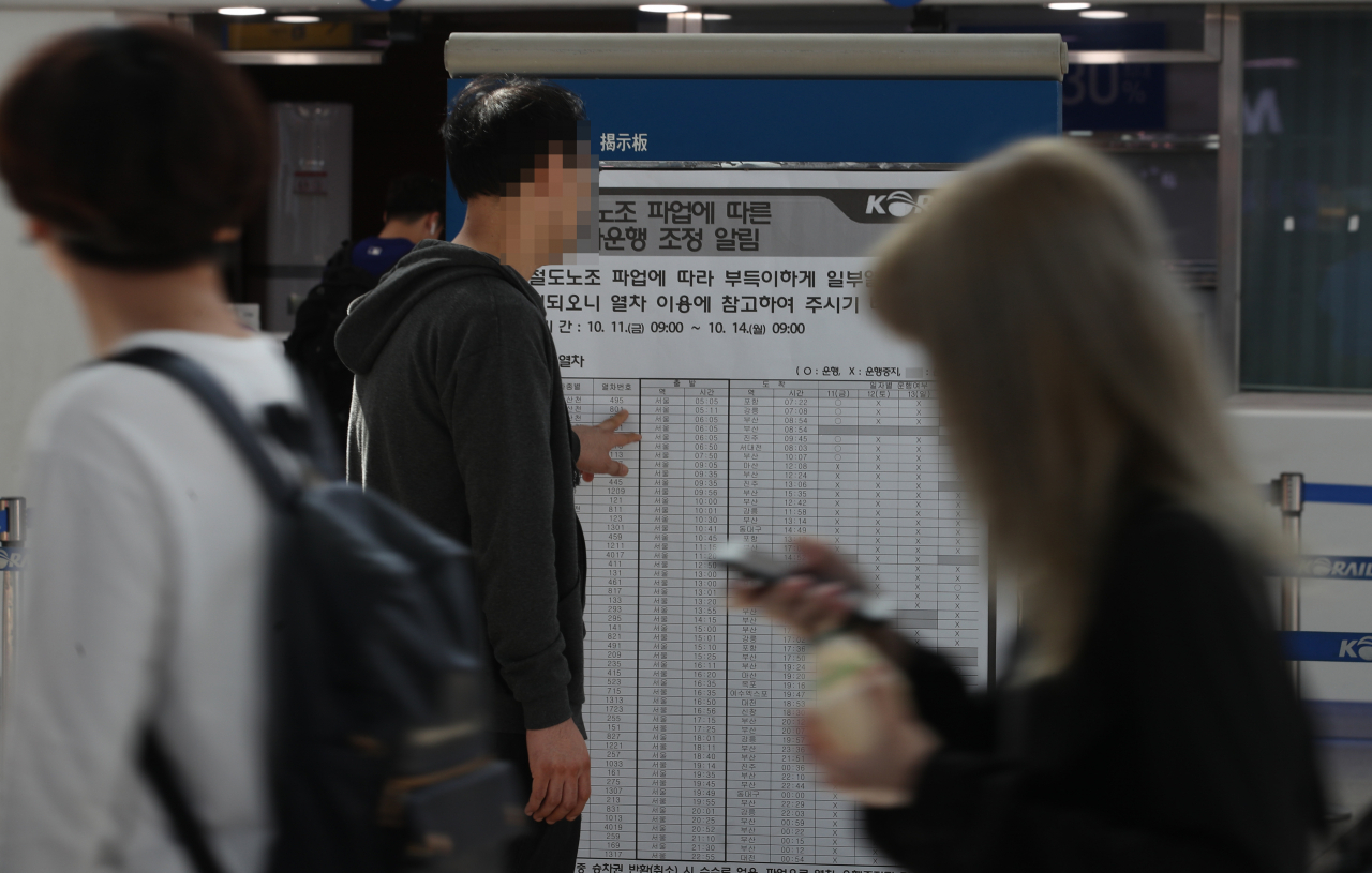 전국 철도노동조합 한시 파업 사흘째인 13일 오전 서울역에서 한 시민이 파업에 따른 열차운행 조정을 알리는 게시물을 보고 있다. 노조는 총인건비 정상화, 노동시간 단축과 철도안전을 위해 2020년 1월 1일부터 시행하기로 한 4조 2교대 근무 형태 도입을 위한 안전인력 충원, 생명안전업무 정규직화와 자회사 처우개선 등 노·사·전문가협의체 합의 이행을 요구하고 있다. 연합뉴스