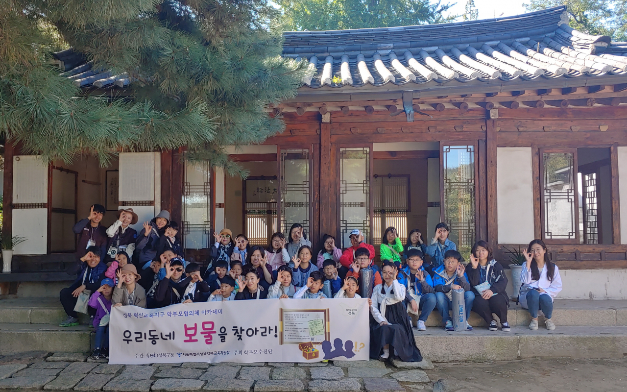 성북동 일대에서 열린 혁신교육프로그램 '우리동네 보물찾기'에 참가한 가족 단위 참가자들이 심우장 앞에서 기념촬영을 하고 있다. [성북구 제공]
