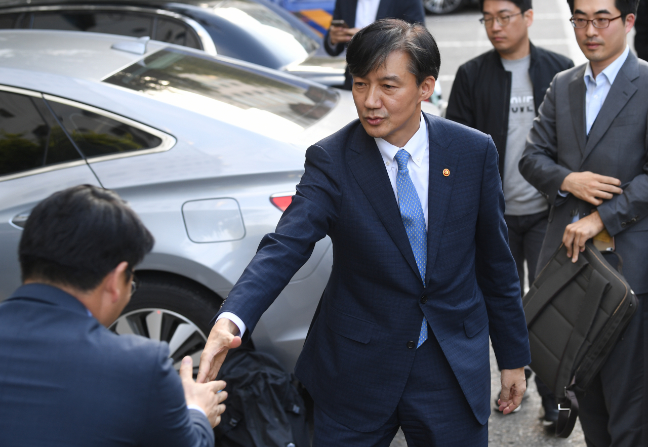 전격적으로 사의를 밝힌 조국 법무부 장관이 14일 오후 방배동 자택으로 들어가던 중 법무부 관계자들과 인사를 나누고 있다. 연합뉴스