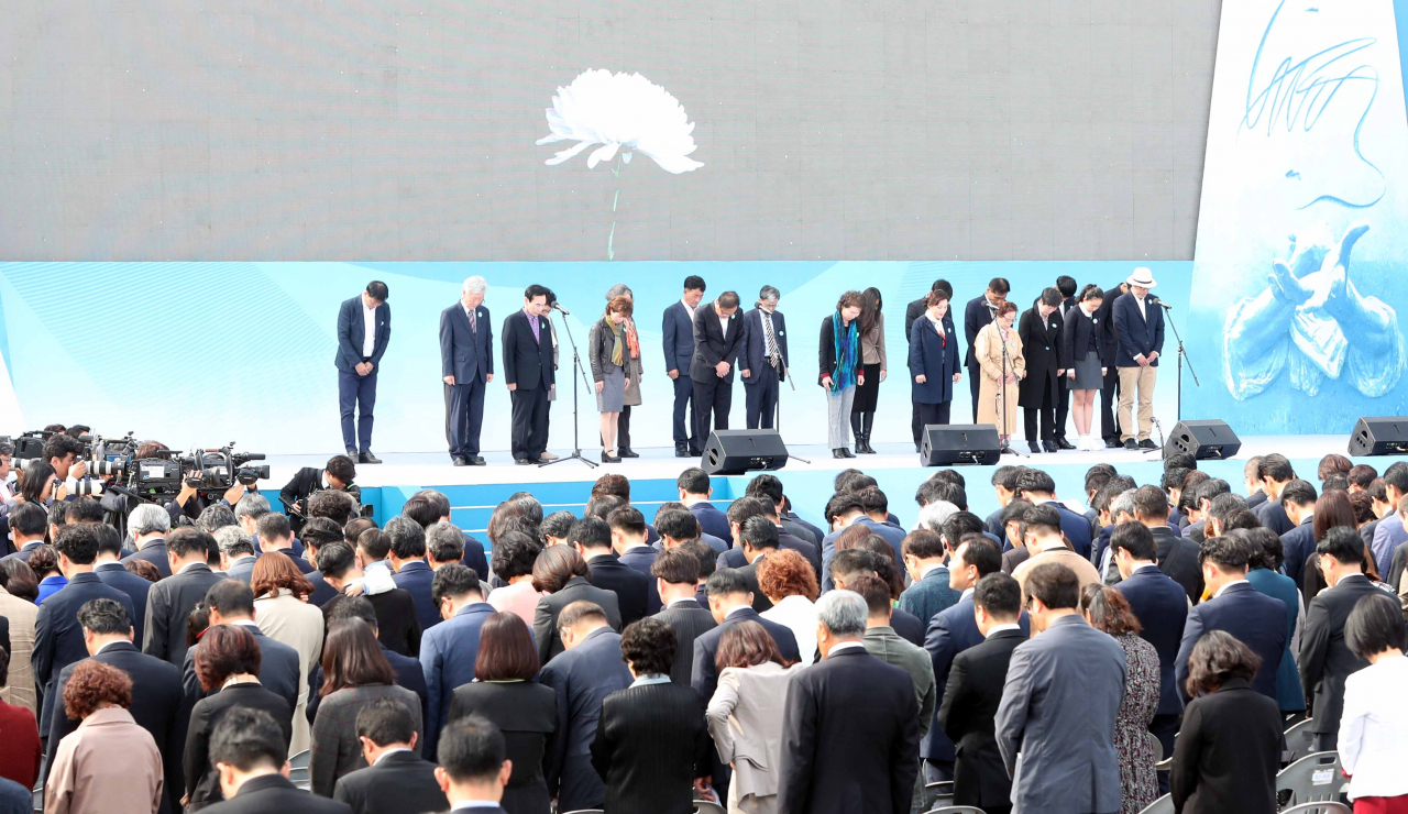 16일 오전 경남 창원시 마산합포구 경남대 대운동장에서 열린 ‘제40주년 부마민주항쟁 기념식’에서 문재인 대통령을 비롯한 참석자들이 순국선열과 민주열사에 대해 묵념하고 있다. [연합]