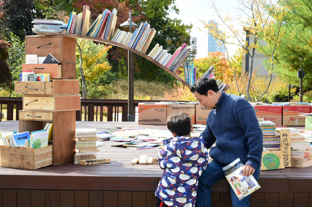 중랑 북페스티벌에서 아빠와 아이가 책읽기의 즐거움에 빠져있다. [중랑구 제공]