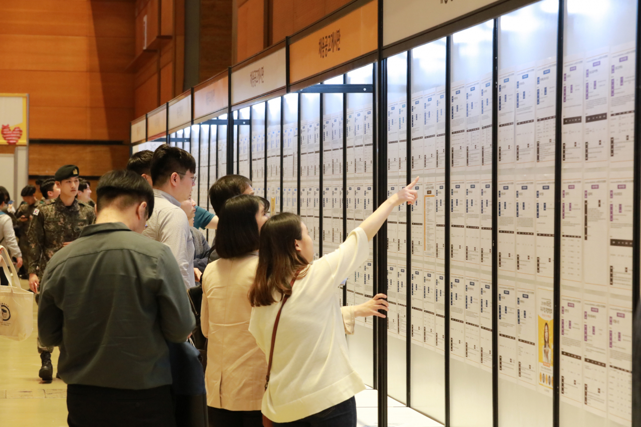 지난 5월 서울 강남구 삼성동 코엑스에서 열린 2019년 1차 ‘KB굿잡 우수기업 취업박람회’를 찾은 구직자들이 게시판을 살피고 있다. [KB국민은행 제공]