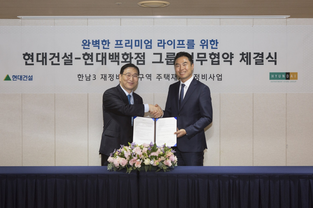 [사진=16일 서울 종로구 계동 현대건설 본사 사옥에서 윤영준 현대건설 주택사업본부장 전무(왼쪽)와 현대백화점 영업본부장 정지영 부사장이 한남3구역 현대백화점 입점을 위한 업무협약을 맺고 악수를 나누고 있다. 현대건설 제공]
