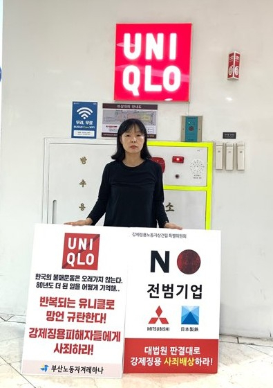 [사진=19일 오후 부산 부산진구 서면 롯데백화점 지하상가 유니클로 매장 앞에서 부산노동자겨레하나 회원이 종군 위안부 할머니를 조롱하는 듯한 광고를 내보낸 일본기업 유니클로를 규탄하는 1인 시위를 벌이고 있다. 유니클로는 최근 공개한 광고에서 90대 할머니가 10대 여성으로부터 "제 나이 때는 어떻게 입었냐"는 질문에 "80년도 더 된 일을 기억하냐고?"라는 의역된 자막을 실어 위안부 할머니를 조롱한 것 아니냐는 비판을 받았다. 연합뉴스 제공.]