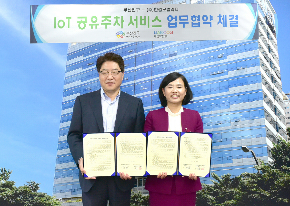 〈사진〉IoT 공유주차 서비스 제공을 위한 업무협약식에 참석한 최천우 한컴모빌리티 공동 대표이사(사진 왼쪽)와 서은숙 부산 진구청장이 기념사진을 촬영하고 있다 [한컴 제공]