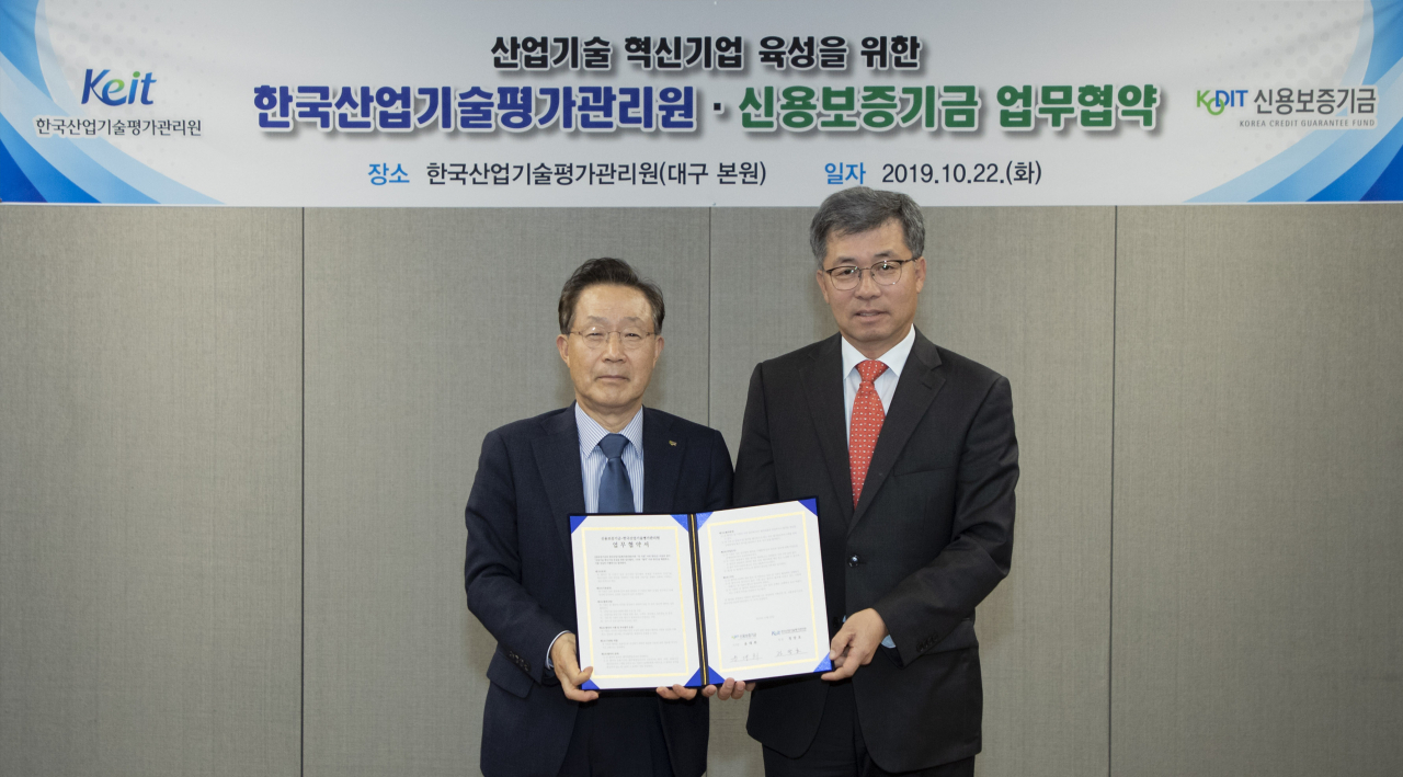 윤대희 신용보증기금 이사장(왼쪽)이 정양호 한국산업기술평가관리원 원장과 함께 22일 대구혁신도시 내 한국산업기술평가관리원 본원에서 열린 ‘산업기술 혁신기업 육성을 위한 업무협약’에서 기념촬영을 하고 있다.