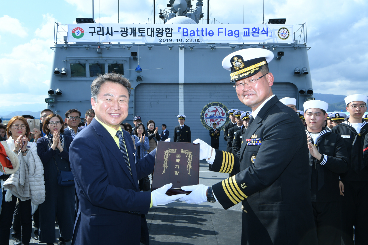 배틀플래그를 교환하고 있는 안승남 구리시장(왼쪽)과 김진우 광개토대왕함장