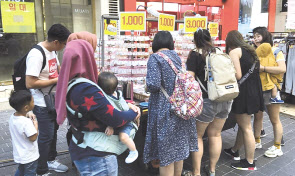외국인 관광객들이 서울 명동에서 쇼핑하는 모습. 뒷편 매장에는 임대 현수막이 걸려있다.