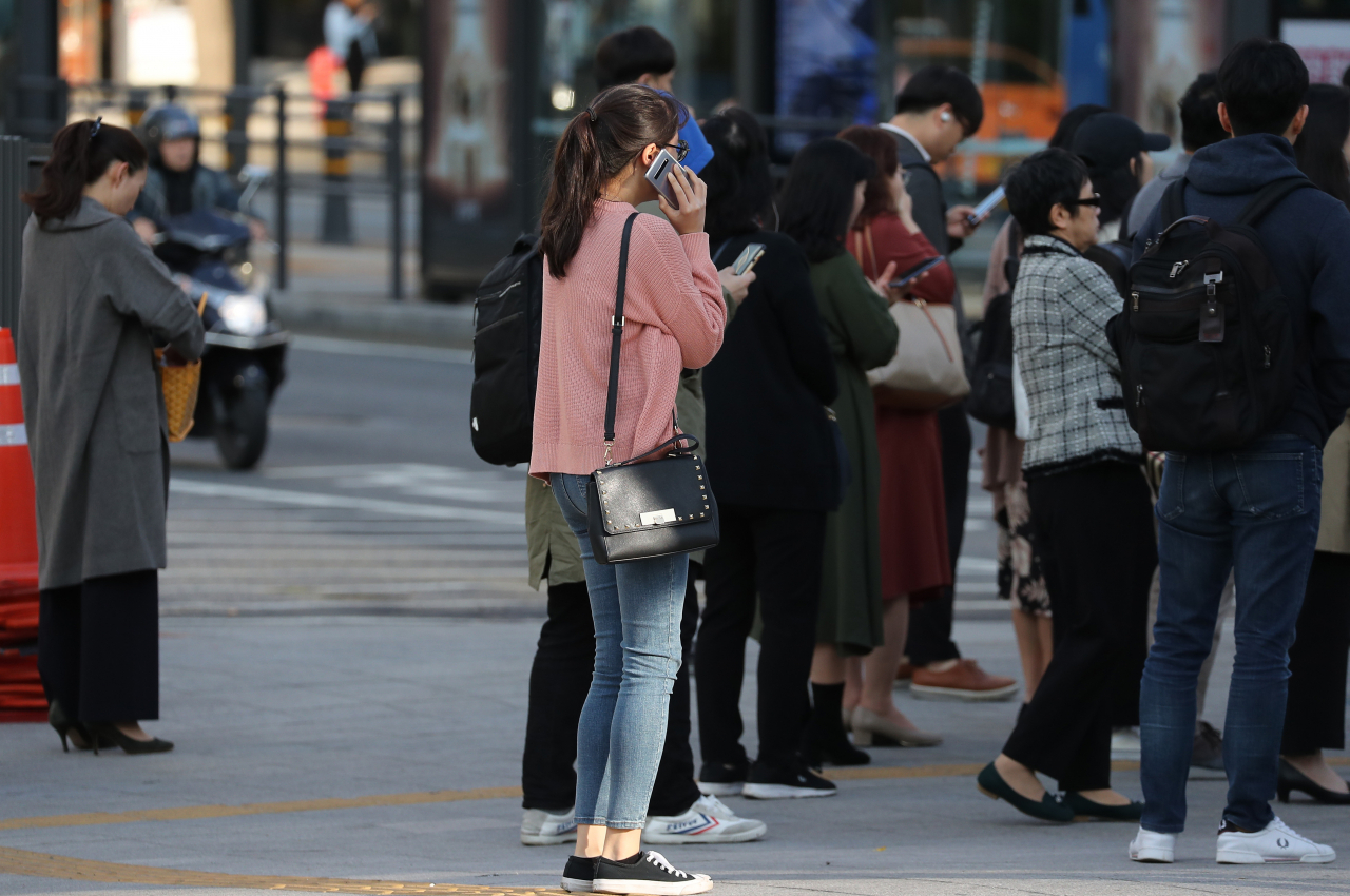 서울을 비롯한 수도권의 아침 기온이 영상 10도 내외를 기록한 15일 오전 서울 종로구 세종로사거리에서 시민들이 신호를 기다리고 있다. 연합뉴스