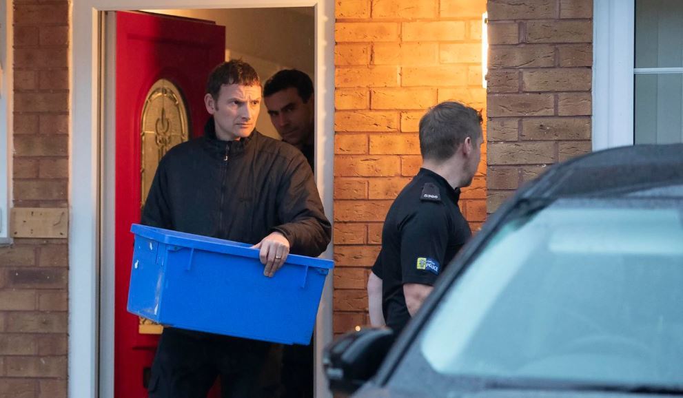 Police leave the home of Joanna and Thomas Maher with an evidence box at Wiltshire close in Warrington, Cheshire, Friday, Oct. 25, 2019, after a man and a woman, both aged 38 and from Warrington, have been arrested on suspicion of manslaughter and conspiracy to traffic people in connection with the 39 bodies found in a lorry in Essex on Wednesday. (AP)